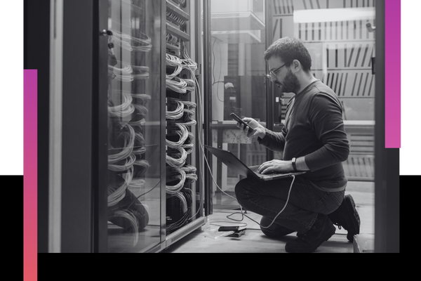 man holds laptop in data center tech room Network 1 (2).png