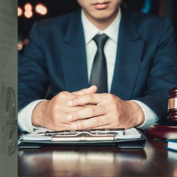 attorney with hands folded sitting at desk