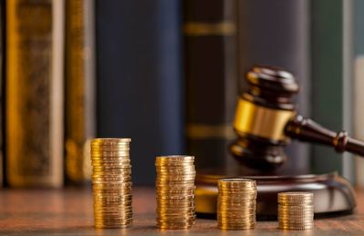 gavel behind stack of coins