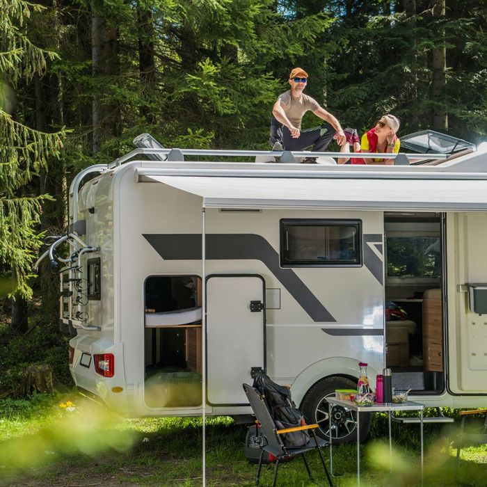Couple sitting on top of an RV in nature