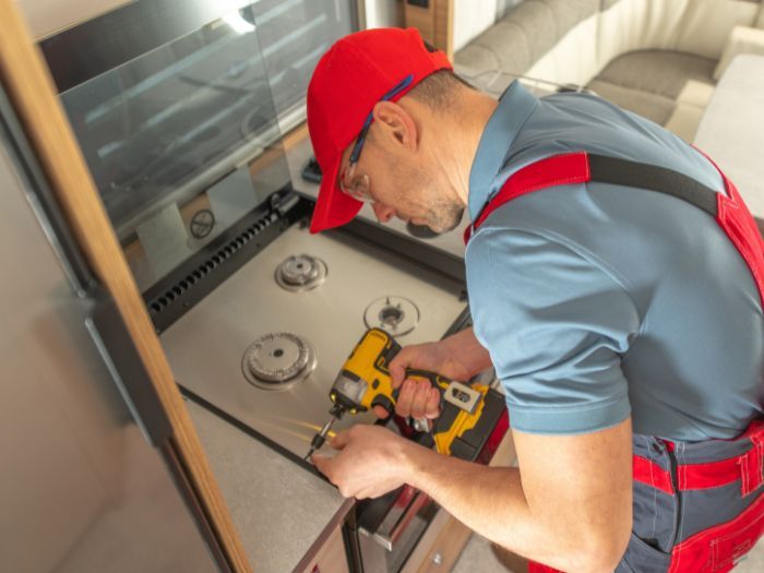 Man repairing RV stove appliance