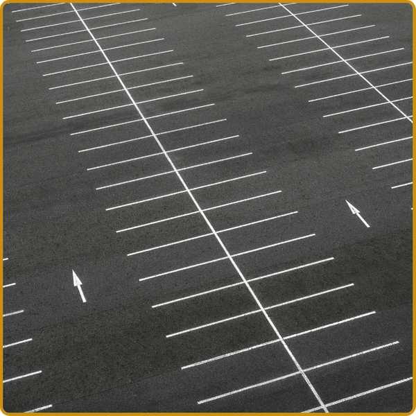 A top-down view showing diverse pavement markings, including a clear accessible parking symbol, a directional arrow, and a numbered parking stall, illustrating comprehensive striping services.