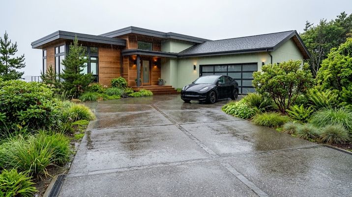 Finished permeable concrete paver driveway draining rainwater cleanly in front of a coastal home.