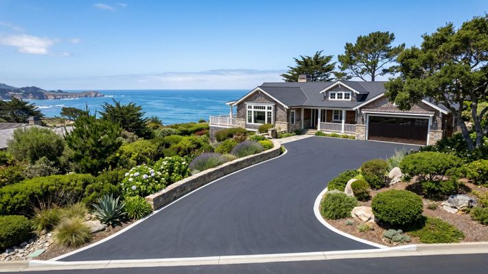 A flawlessly paved residential asphalt driveway leading to a Monterey coastal home with professional landscaping.
