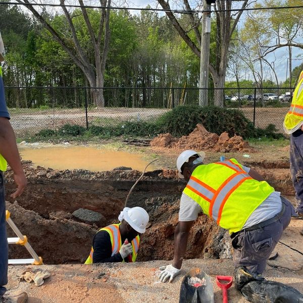 Construction workers inspecting underground utilities Construction workers inspecting underground utilities
