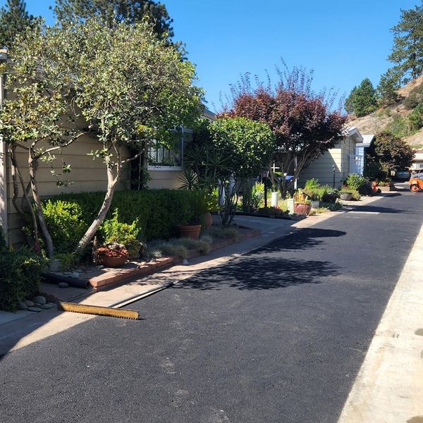 Freshly laid high-performance asphalt driveway with a paving lute resting on the new surface. Freshly laid high-performance asphalt driveway with a paving lute resting on the new surface.