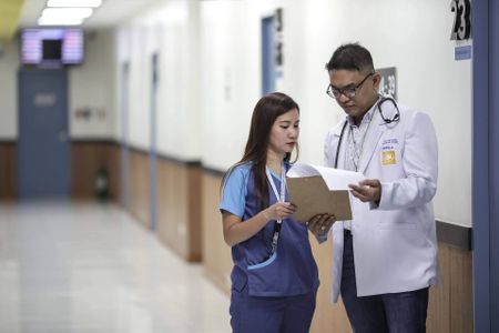 Image of a doctor and a nurse discussing a chart