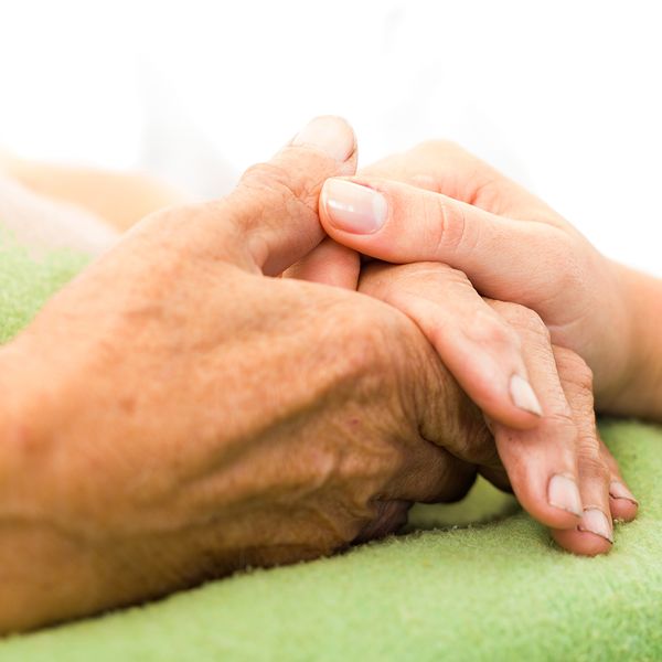 An elderly person's hands holing a young person's hands