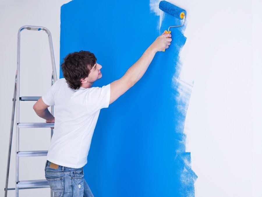 handsome-young-man-painting-wall-blue_186202-2045.jpeg