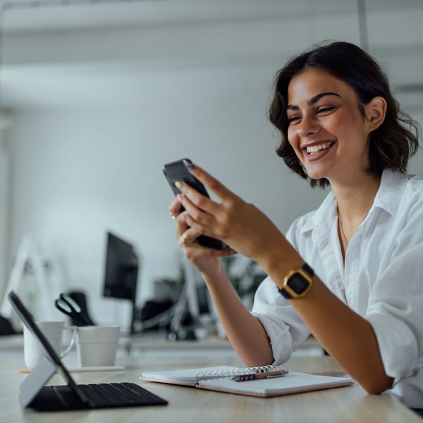 woman typing on her phone and smiling