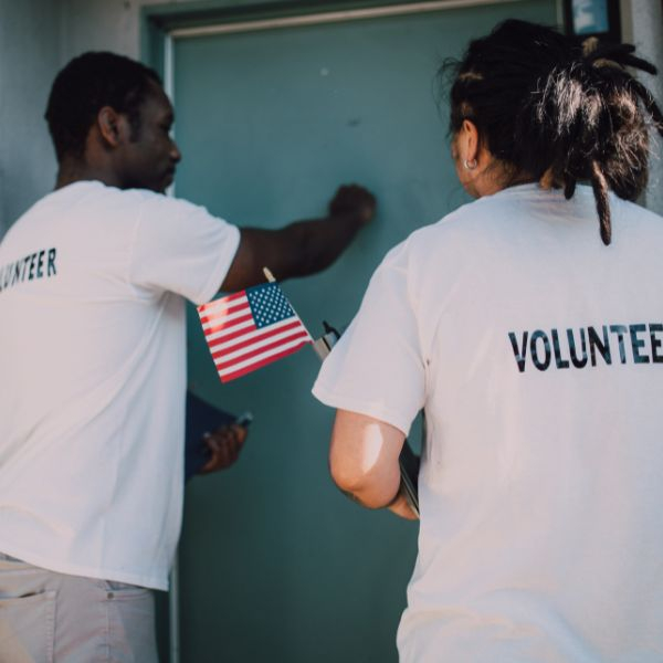 volunteers with flags canvassing door-to-door