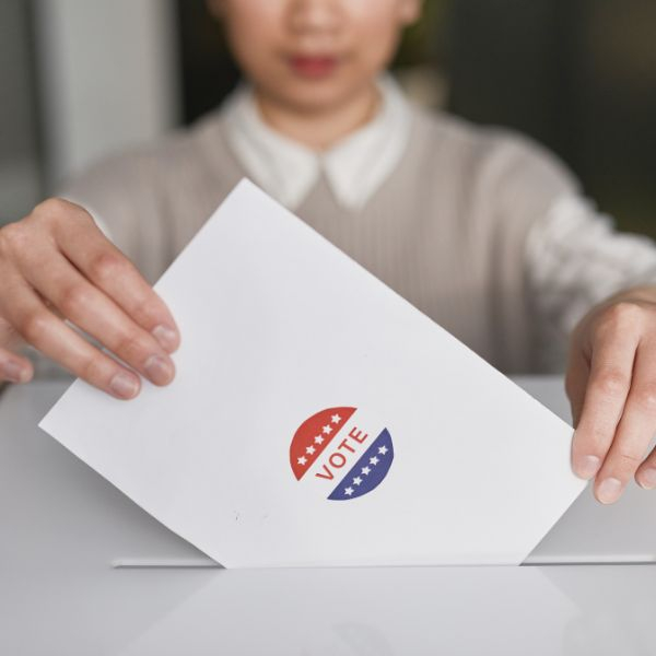 woman placing ballot in voting box