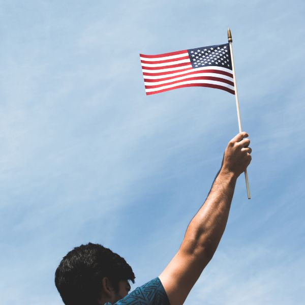 man raising flag to sky