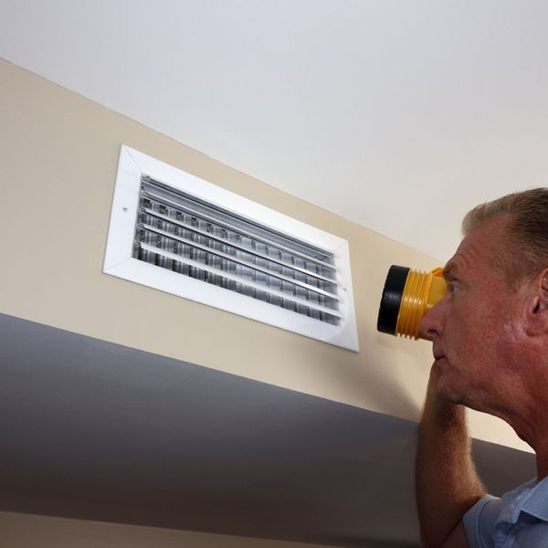 homeowner inspecting air register
