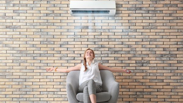 woman who is cool from the AC unit working properly
