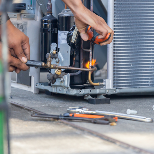 HVAC tech repairing AC unit HVAC tech repairing AC unit