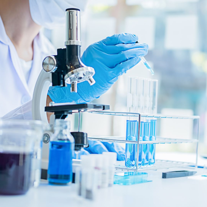 scientist using a pipette with vials