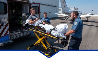 Image of a person on a gurney  being transported to an air plane