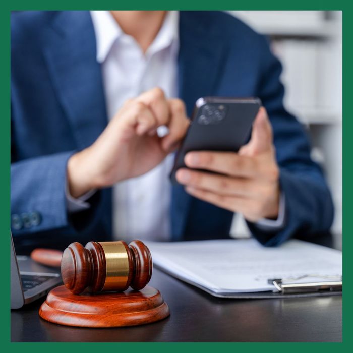 Lawyer working on his phone with papers in front of him