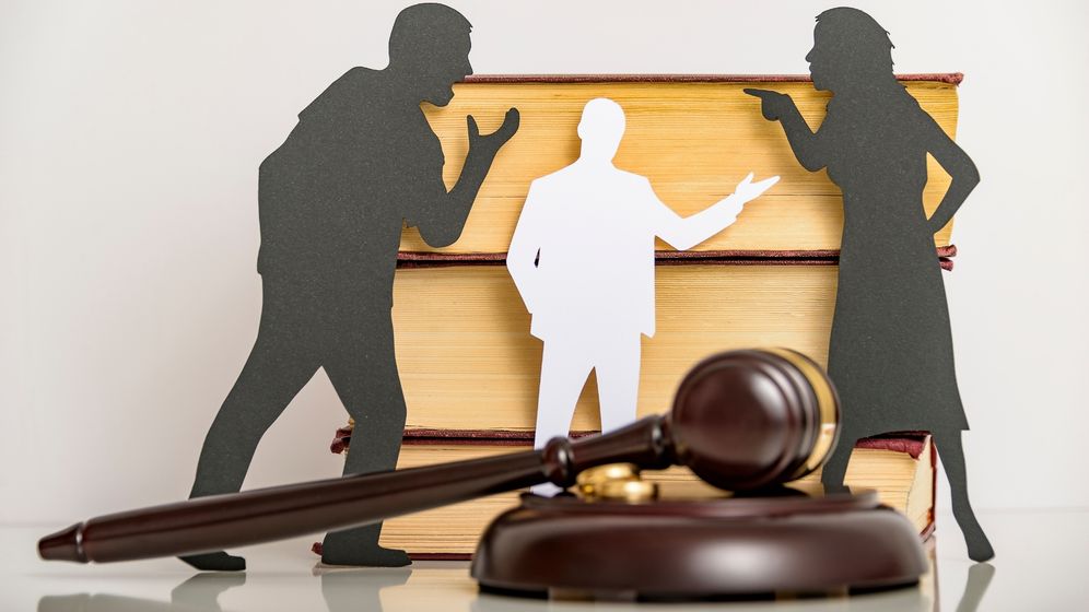 Cutouts of a couple arguing behind a gavel