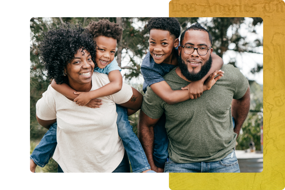 a mother and father are giving piggyback rides to their two young, smiling sons.