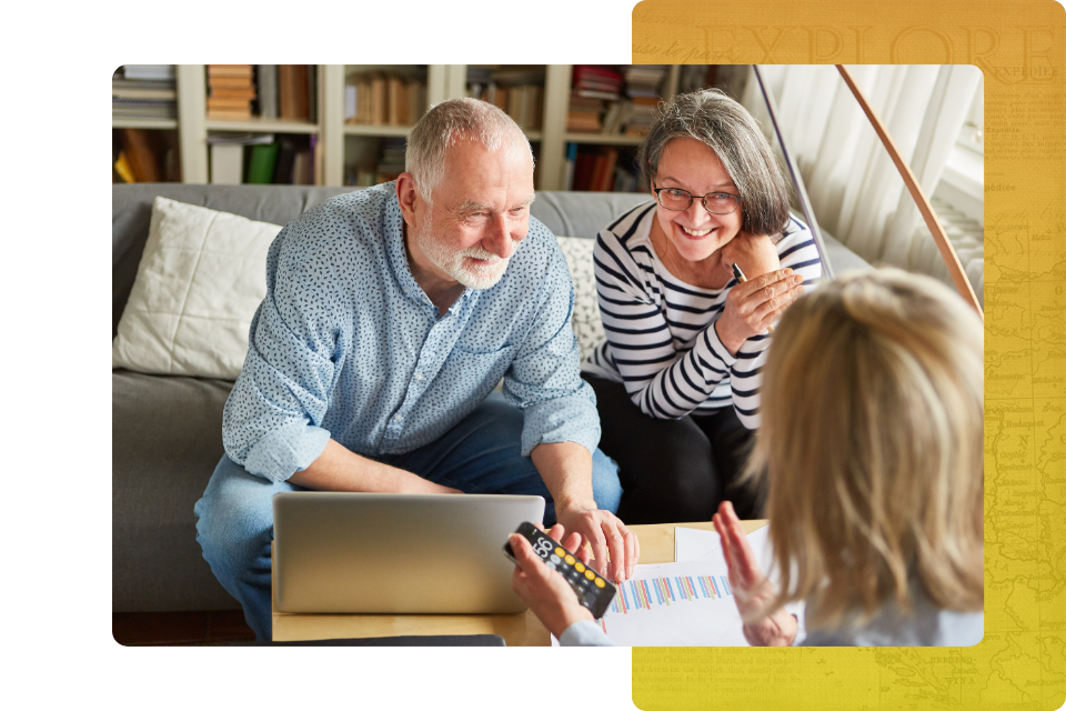two women and one man sitting across table engaged in a collaborative discussion over open files.