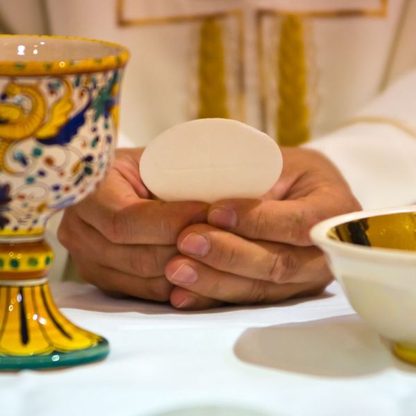 priest holding Eucharist