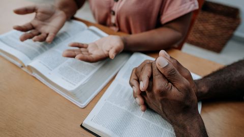 couple with hands on bible