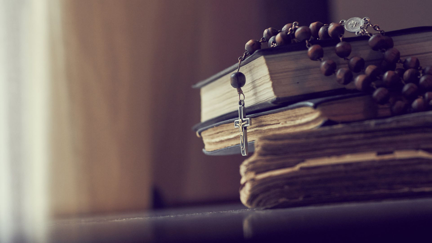 Rosary and stack of books