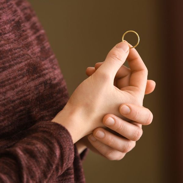 a person holding their wedding ring