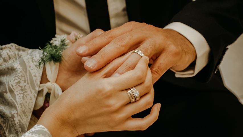 Married couple putting each others rings on