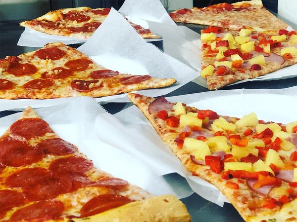 lots of pizza slices laid out on table