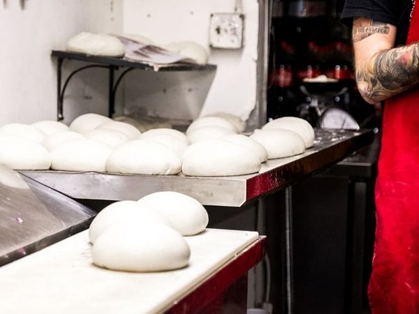 Pizza baker making balls of pizza dough