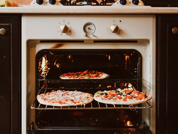 photo of pizzas in an oven