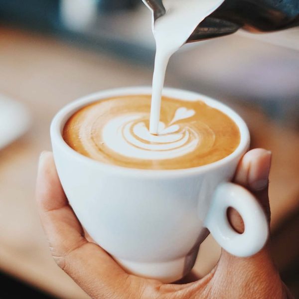 person pouring a latte