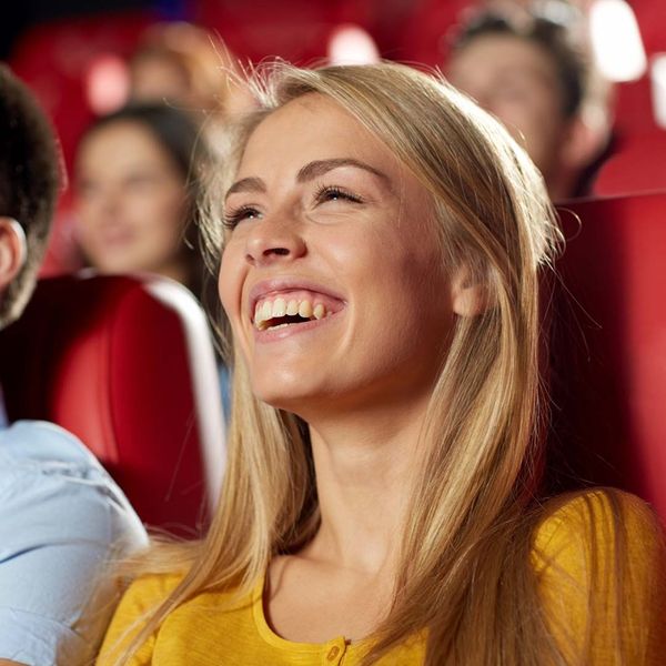 happy friends watching comedy movie in theater