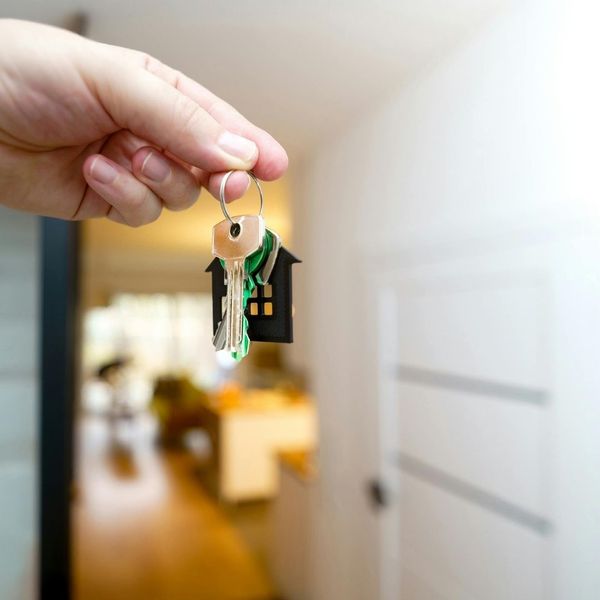 holding keys in front of door to home