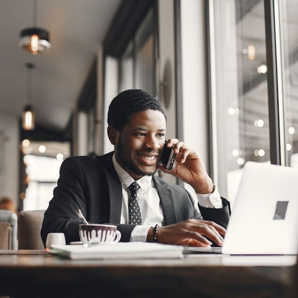 man in suit on the phone working on laptop