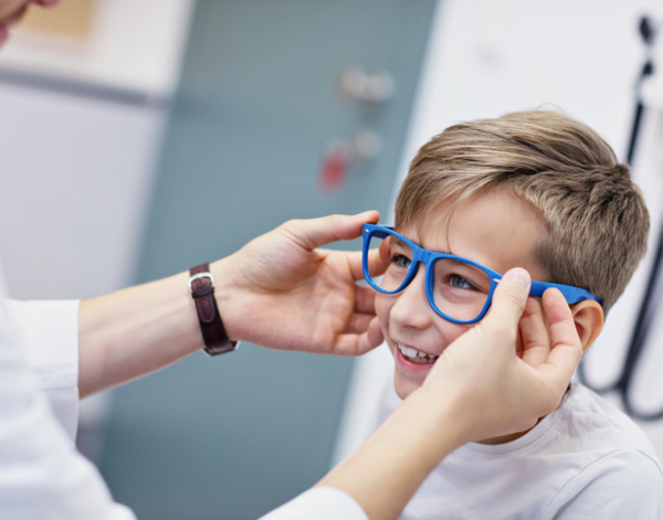 doctor putting glasses in kid