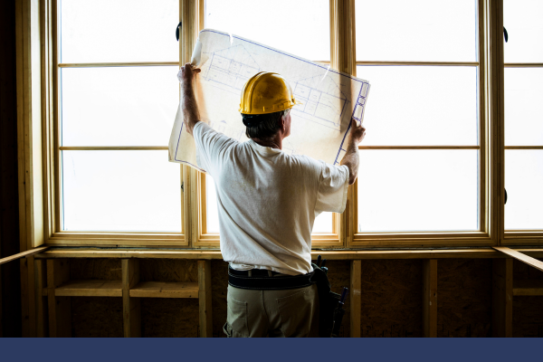 construction worker holding up a blueprint. 