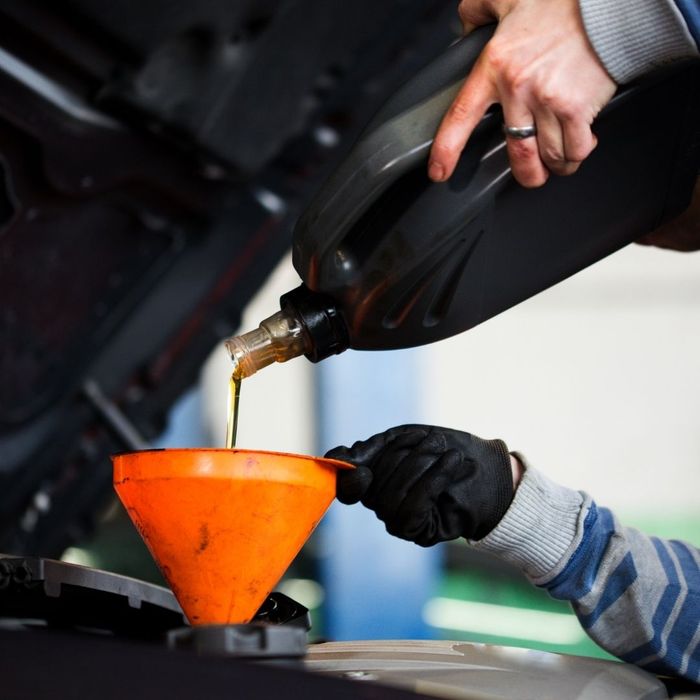 mechanic pouring oil