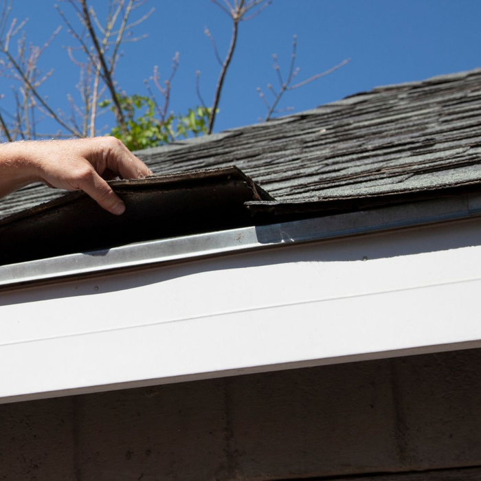 inspecting shingles on roof 1080x1080-ProtectingHomeFromWind1.jpg