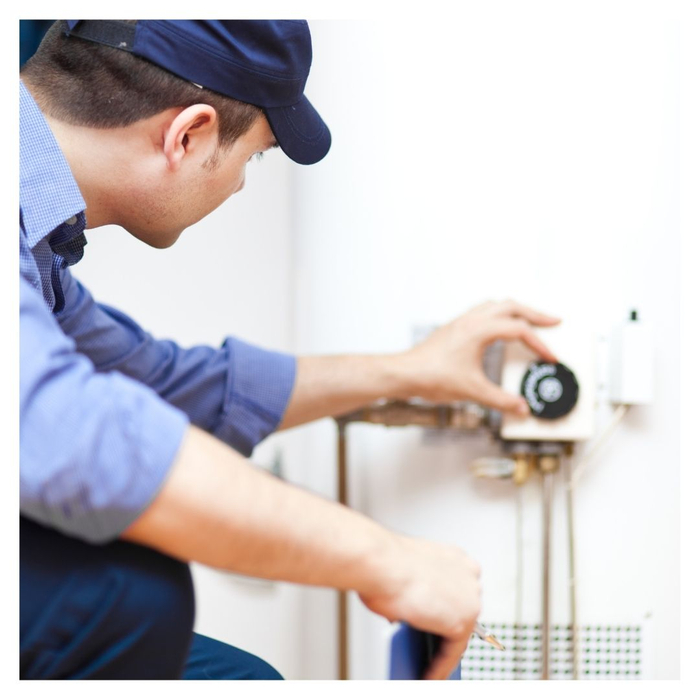 A worker adjusting the temperature on a water heater Our Top Tips for Extending the Lifespan of Your Water Heater 2.jpg