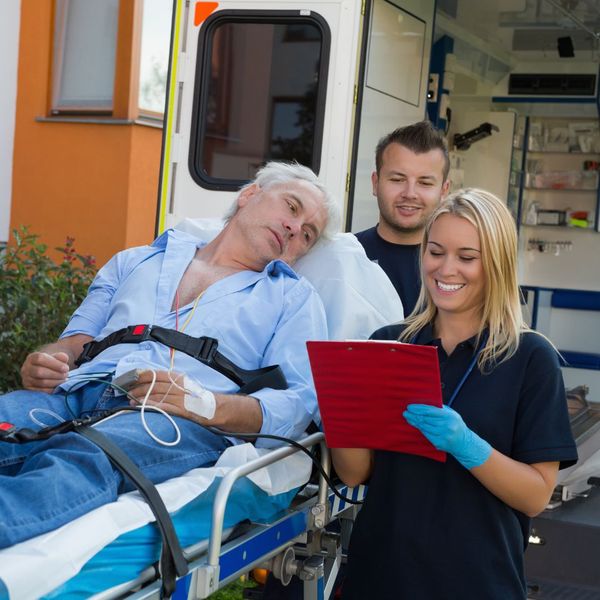 older man being loaded into a van on a stretcher