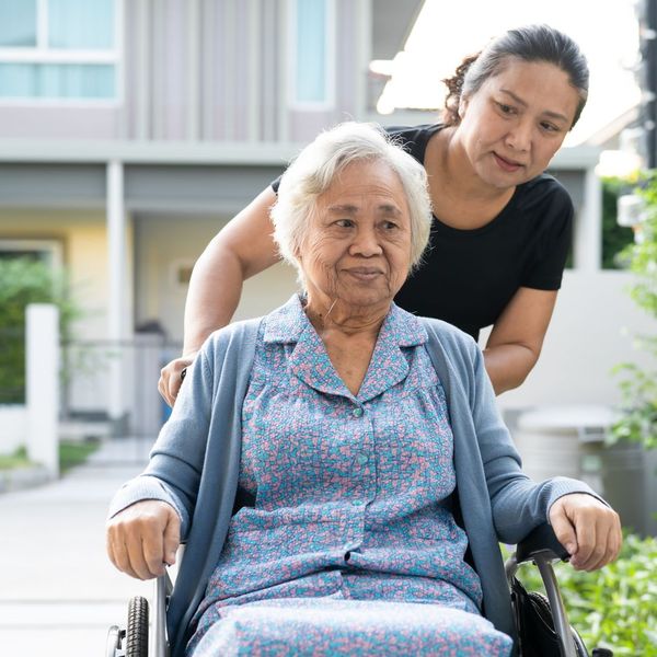 older woman being pushed in a wheelchair