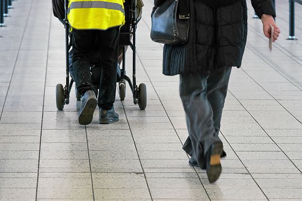 people in an airport pushing a wheel chair