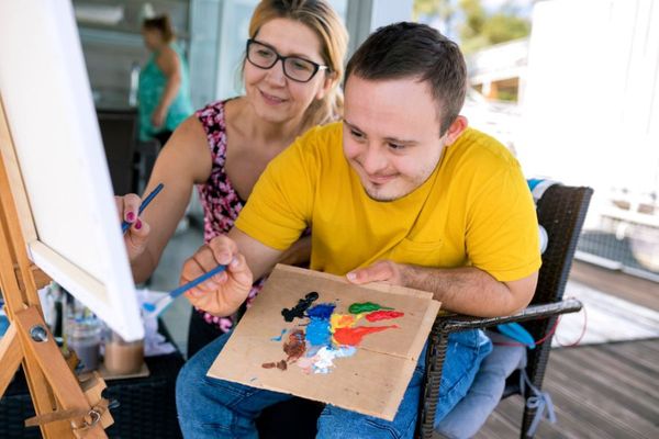 adult male with special needs painting