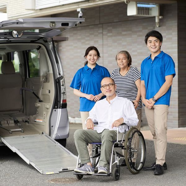 two-man assistance loading a wheelchair into a van