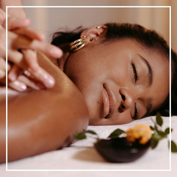 Close-up of a serene woman receiving a professional neck and shoulder massage, eyes closed in relaxation at a specialized massage sanctuary.