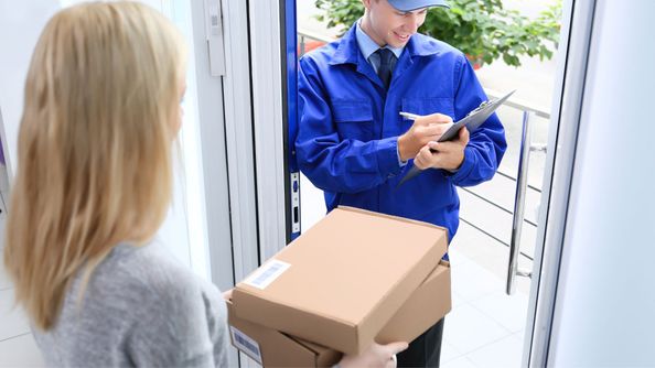 mailman handing lady a box